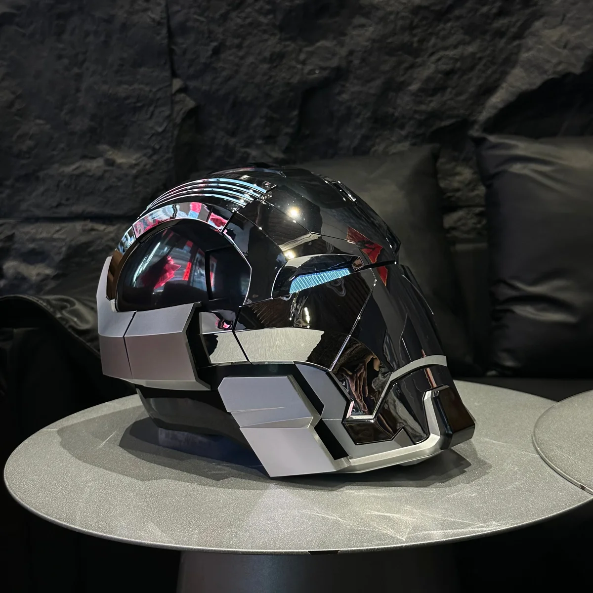 Black chrome Iron Man MK17 Heartbreaker helmet in profile on a table